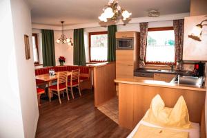 eine Küche und ein Wohnzimmer mit einem Tisch, einer Küche und einem Esszimmer in der Unterkunft Komfort Appartement Royal Windberger in Schladming