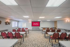 a conference room with tables and chairs and a screen at Red Roof Inn & Suites Mt Holly - McGuire AFB in Westampton Township