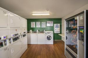a laundry room with white appliances and green walls at HomeTowne Studios by Red Roof Spartanburg - Asheville Highway in Southern Shops