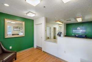 una sala de espera vacía con paredes verdes y un mostrador en HomeTowne Studios by Red Roof Spartanburg - Asheville Highway, en Southern Shops