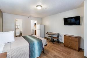 a hotel room with a bed and a television at HomeTowne Studios by Red Roof Atlanta – Lawrenceville in Lawrenceville