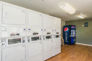 a row of white machines in a room with a soda machine at HomeTowne Studios by Red Roof Denver - Thornton in Thornton