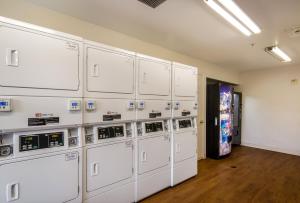 a room with a bunch of white machines on the wall at HomeTowne Studios by Red Roof Denver - Airport/Aurora in Aurora