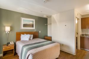 a hotel room with a bed and a sink at HomeTowne Studios by Red Roof Denver - Airport/Aurora in Aurora +15 photos