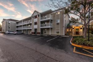 a parking lot in front of a apartment building at HomeTowne Studios by Red Roof Orlando - Casselberry in Orlando