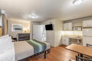 um quarto de hotel com uma cama e uma cozinha em HomeTowne Studios by Red Roof Orlando - Casselberry em Orlando