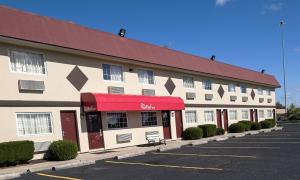 un edificio con toldo rojo en un estacionamiento en Red Roof Inn Dayton Huber Heights, en Dayton