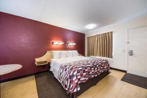 a hotel room with a bed and a red wall at Red Roof Inn Laredo in Laredo