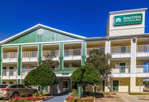 a front view of a hotel with a car parked in front at HomeTowne Studios Houston - West Oaks in Houston