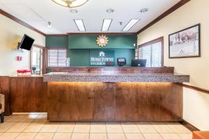 a lobby of a hotel room with a reception counter at HomeTowne Studios by Red Roof Gainesville, GA in Gainesville