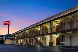 een uitzicht op een parkeerplaats van het hotel met een motelbord bij Red Roof Inn Caryville in Caryville