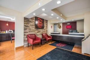 a waiting area at a fast food restaurant with red chairs at Red Roof Inn Caryville in Caryville