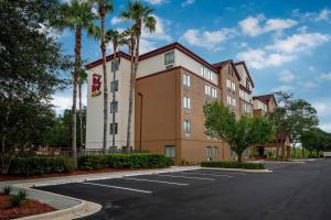 a building with palm trees in a parking lot at Red Roof Inn PLUS+ Jacksonville – Southpoint in Jacksonville