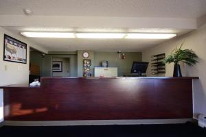 a waiting room with a large wooden reception desk at HomeTowne Studios by Red Roof Denver - Lakewood West in Lakewood