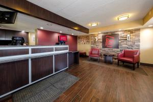 a bar with red chairs in a waiting room at Red Roof Inn Lansing East - MSU in Lansing