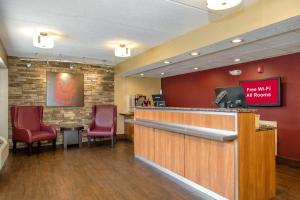 un bar con sillas rojas y una sala de espera en Red Roof Inn Tallahassee - University, en Tallahassee