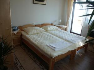 a bedroom with a bed with white sheets and a window at Pri Lazarju Farm Stay in Podgrad