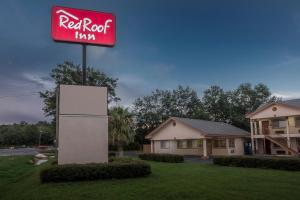 une enseigne d'auberge au toit rouge devant une maison dans l'établissement Red Roof Inn Chipley, à Chipley