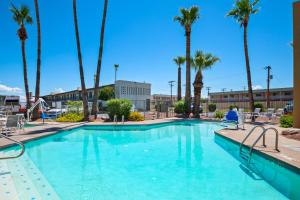 a large swimming pool with palm trees in a resort at Red Roof Inn Tucson Downtown - University in Tucson