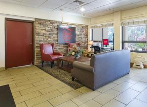 a lobby with a waiting room with a couch and chairs at Red Roof Inn Montgomery - Midtown in Montgomery