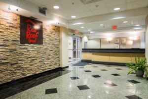 a lobby with a red roof inn sign on a wall at Red Roof Inn & Suites Philadelphia - Bellmawr in Bellmawr