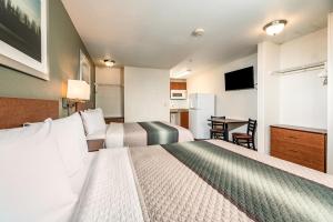 a hotel room with two beds and a kitchen at HomeTowne Studios by Red Roof Fresno - West in Fresno