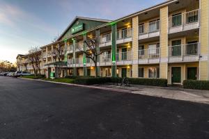 an empty street in front of a hotel at HomeTowne Studios by Red Roof Fresno - West in Fresno