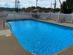 a large blue swimming pool next to a white fence at Red Roof Inn Portsmouth - Wheelersburg in Wheelersburg