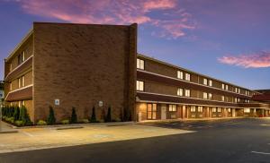 an empty parking lot in front of a brick building at Red Roof Inn PLUS+ Columbus - Worthington in Columbus