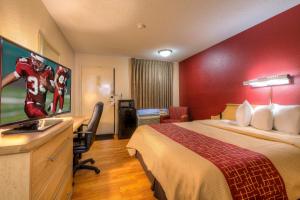 a hotel room with a large bed and a television at Red Roof Inn Tulsa in Tulsa