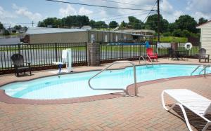 a swimming pool with chairs and a bench next to it at Red Roof Inn Somerset, KY in Somerset