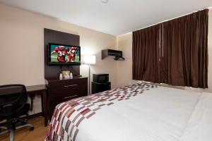 a hotel room with a bed and a flat screen tv at Red Roof Inn Norfolk - Portsmouth in Portsmouth