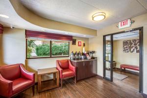 una sala de espera con 2 sillas rojas y un bar en Red Roof Inn Detroit - Plymouth/Canton, en Plymouth