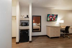 a hotel room with a bed and a desk and a bedroom at Red Roof Inn Indianapolis - Greenwood in Greenwood