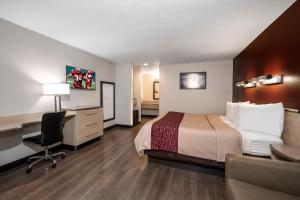 a hotel room with a bed and a desk at Red Roof Inn Indianapolis - Greenwood in Greenwood
