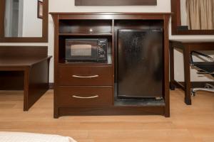 a cabinet with a microwave and a refrigerator in a room at Red Roof Inn Morgan City in Morgan City