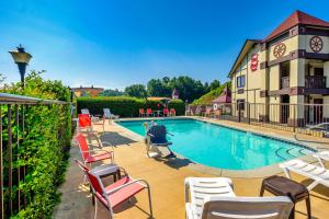 a swimming pool with chairs and a building at Red Roof Inn Helen in Helen