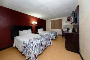 A bed or beds in a room at Red Roof Inn Jacksonville - Cruise Port