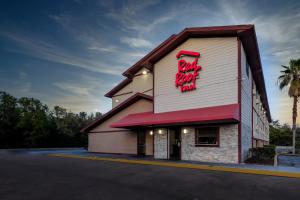 a fast food restaurant with a red neon sign on it at Red Roof Inn Jacksonville - Cruise Port in Jacksonville