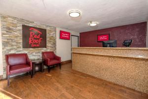 a red roof inn lobby with red chairs and a bar at Red Roof Inn Jacksonville - Cruise Port in Jacksonville