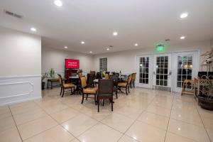 a dining room with tables and chairs in a restaurant at Red Roof Inn & Suites Wilson in Wilson