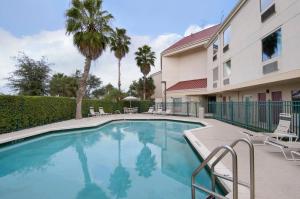 a swimming pool in front of a building at Red Roof Inn PLUS+ West Palm Beach in West Palm Beach