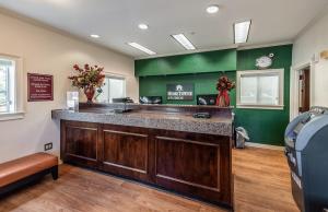 a bar in a waiting room with green walls at HomeTowne Studios by Red Roof Orlando South in Orlando