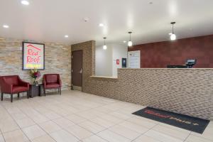 a waiting room with two red chairs and a red roof at Red Roof Inn PLUS+ Fort Worth - Burleson in Burleson
