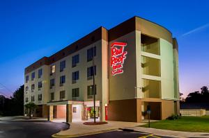a hotel building with a neon sign on it at Red Roof Inn & Suites Fayetteville-Fort Bragg in Fayetteville