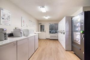 a large kitchen with white cabinets and appliances at HomeTowne Studios by Red Roof Raleigh – Durham in Durham