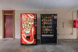a soda vending machine next to a brick wall at Red Roof Inn Fredericksburg North in Fredericksburg