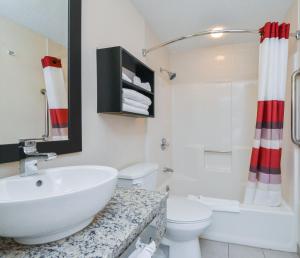 a bathroom with a sink and a toilet at Red Roof Inn PLUS+ & Suites Guilford in Guilford +14 photos