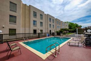 a swimming pool at a hotel with chairs and a building at Red Roof Inn Pensacola Fairgrounds in Pensacola