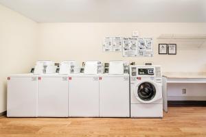 a group of washing machines and a washer and dryer at HomeTowne Studios by Red Roof Rancho Cordova in Rancho Cordova